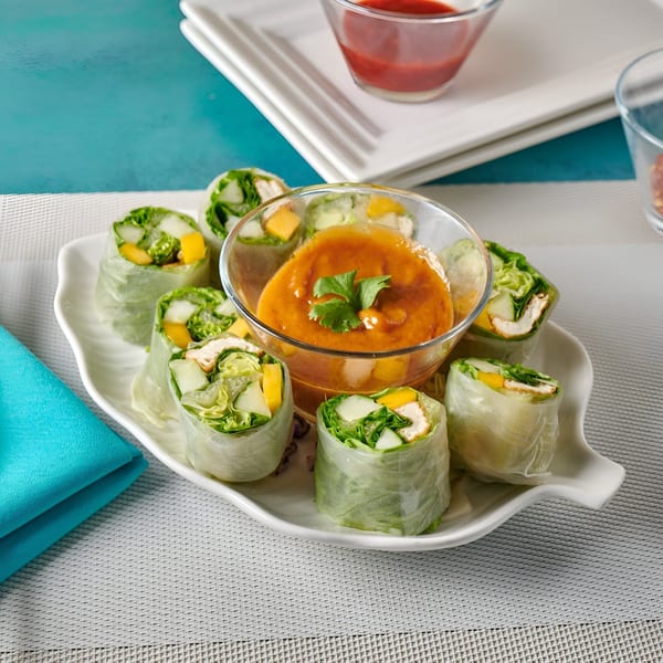 Blue Mango's fresh spring rolls with mango, chicken, and vegetables, served with a peanut dipping sauce.